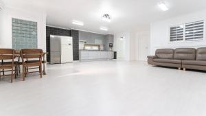 a large living room with a couch and a kitchen at Taean Dokchae Trudy Pension in Taean