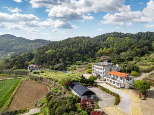 an aerial view of a house and a farm at Namhae Camp Village in Namhae