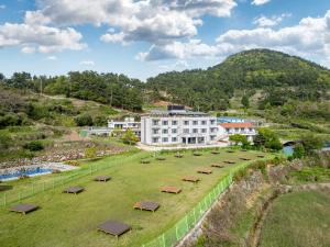a group of benches in a field in front of a building at Namhae Camp Village in Namhae