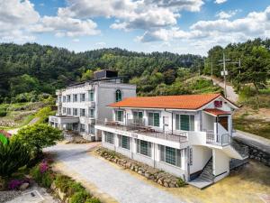 an aerial view of a white building with an orange roof at Namhae Camp Village in Namhae +41 photos