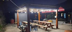 a picnic table under a shed at night at Yeosu Geumodo Badaae Pension in Yeosu