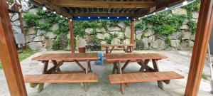 a group of picnic tables sitting under a pavilion at Yeosu Geumodo Badaae Pension in Yeosu