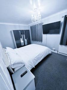 una camera da letto con un letto bianco e un lampadario di Mona a Hull