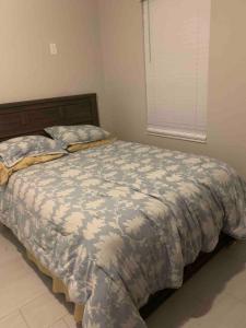 a bedroom with a bed with a comforter and a window at Orlando 4 bedroom built in 2021 in Orlando