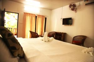 Una televisión o centro de entretenimiento en Backwater Retreat Kumarakom