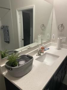 a bathroom with a sink and a large mirror at Orlando 4 bedroom built in 2021 in Orlando