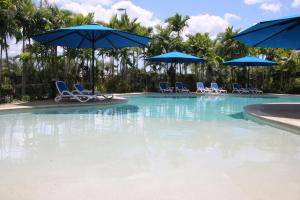 a large swimming pool with chairs and umbrellas at Quality Resort Parkhurst in Rockhampton