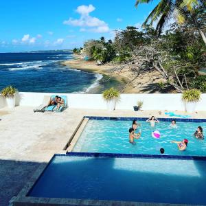 um grupo de pessoas numa piscina ao lado da praia em Hotel Colombus em Aguada
