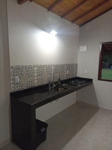 a kitchen with a sink and a counter top at Chalé caminho das cachoeiras in São Thomé das Letras +31 photos