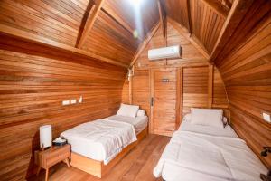 WainapalMulei bungalow Krui的一间木墙房间里有两张床