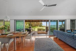a dining room and living room with a table and chairs at Surfbreak, Culburra Beach in Culburra Beach
