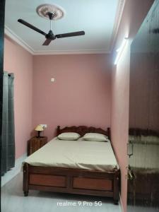 a bedroom with a bed with a ceiling fan at Ferns home stay in Betalbatim