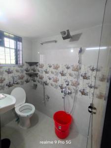 a bathroom with a shower and a toilet and a sink at Ferns home stay in Betalbatim