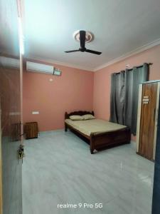 a bedroom with a bed and a ceiling fan at Ferns home stay in Betalbatim