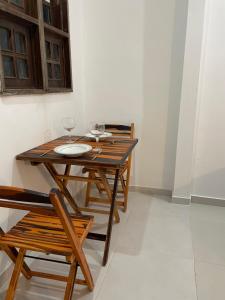 a wooden table with two wine glasses on it at Mini Kitnet-Caraíva- Nova caraiva in Caraíva