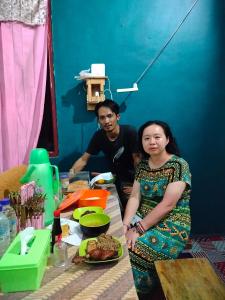 a man and a woman sitting at a table with food at Atta komodo homestay in Komodo +34 photos