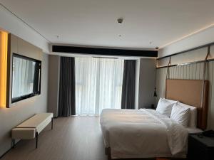 a hotel room with a bed and a large window at FunGeeX in Datong