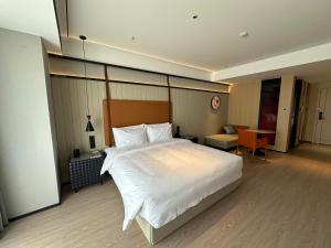 a bedroom with a large white bed and a desk at FunGeeX in Datong