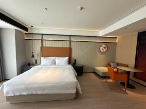 a bedroom with a bed and a table and a chair at FunGeeX in Datong