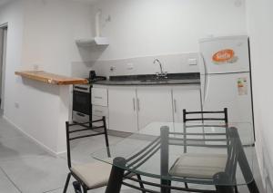 a kitchen with a table and chairs and a refrigerator at Macarena in La Falda