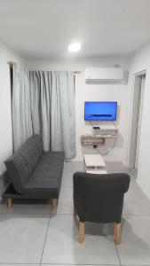 a living room with a couch and a tv at Macarena in La Falda