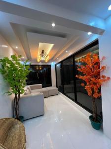 ein Wohnzimmer mit einem Sofa und zwei Bäumen in der Unterkunft Villa Soledad Garden Resort in Sampong