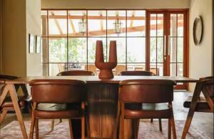 a dining room with a wooden table and chairs at Mountain Villa & Nature Retreat - Fleur de Vie in Bedugul
