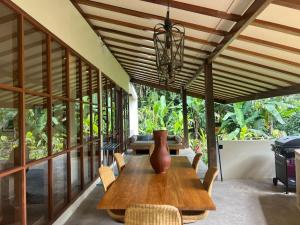 a dining room with a vase on a wooden table at Mountain Villa & Nature Retreat - Fleur de Vie in Bedugul