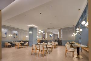 a restaurant with tables and chairs in a room at Meisu Huanzhi Hotel Changsha Wuyi Square Hunan Museum Branch in Changsha