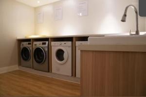 a kitchen with two washing machines and a sink at Meisu Huanzhi Hotel Changsha Wuyi Square Hunan Museum Branch in Changsha