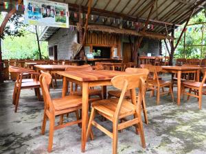 a group of wooden tables and chairs in a restaurant at Hide and Seek in Tetebatu