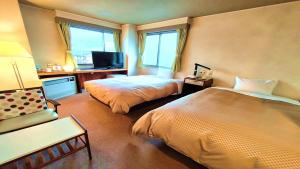 山形市Hotel Sakuranbo的有两张床和一台电视的酒店房间