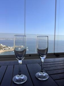 two wine glasses sitting on a table in front of a window at Reñaca, Vista Increíble! in Viña del Mar +24 photos