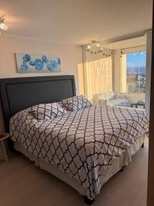 a bedroom with a bed and a large window at Reñaca, Vista Increíble! in Viña del Mar