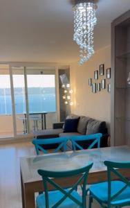 a living room with blue chairs and a chandelier at Reñaca, Vista Increíble! in Viña del Mar
