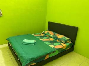 丹戎马林MyLittle Homestay的绿色卧室,配有一张带绿色墙壁的床