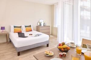 ein Schlafzimmer mit einem Bett und einem Laptop darauf in der Unterkunft Zenitude Quality Aparthotel Le Havre les docks in Le Havre