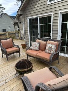 a patio with a couch and chairs on a deck at Royal Pines in New Bern