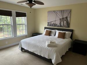 a bedroom with a bed with white sheets and windows at Royal Pines in New Bern