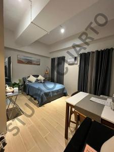um quarto com uma cama e uma escrivaninha em um cômodo em Studiocuarto Cebu Hub em Mandaue City