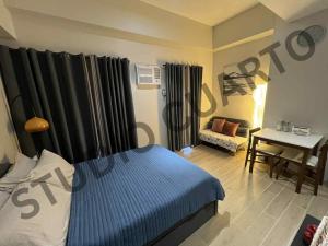 a bedroom with a bed and a table with a desk at Studiocuarto Cebu Hub in Mandaue City