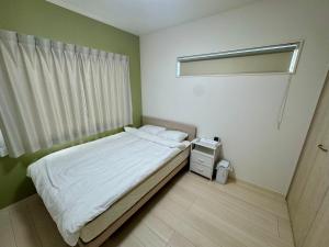 una piccola camera da letto con un letto e una finestra di 嘉翔の家 a Otsu