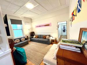 un soggiorno con un divano e un tavolo di Kerrigan's on Seaview- one minute walk to beach - not beachfront views a Henley Beach South