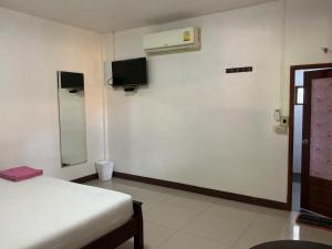 una stanza con un letto e una TV a parete di Pruksa Resort Prachin Buri a Prachin Buri