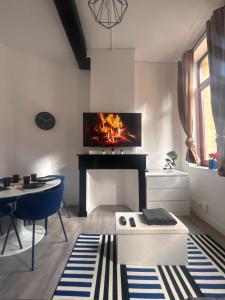 a living room with a fireplace with a tv above it at Le basque in Douai