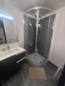 a bathroom with a glass shower and a sink at Le basque in Douai