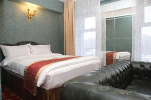 乌兰巴托Roy hotel的带一张床和一张皮沙发的卧室