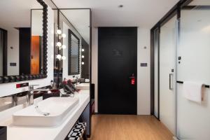 ein Badezimmer mit zwei Waschbecken und einem großen Spiegel in der Unterkunft Radisson Blu Hotel Wuhan Jianghan Road Pedestrian Street in Wuhan + 29 Fotos