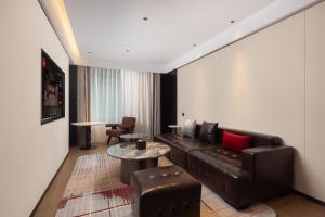 ein Wohnzimmer mit Sofa und Tisch in der Unterkunft Radisson Blu Hotel Wuhan Jianghan Road Pedestrian Street in Wuhan