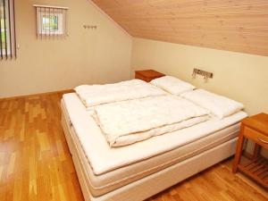 a large white bed in a room with wooden floors at 12 person holiday home in Jelsa in Fuglastein +40 photos